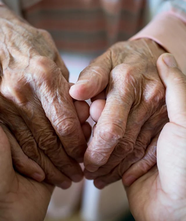 Younger person's hands taking older person's hands