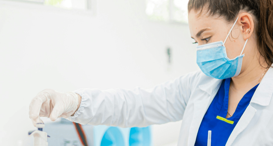 Nurse wearing mask looking at syringe